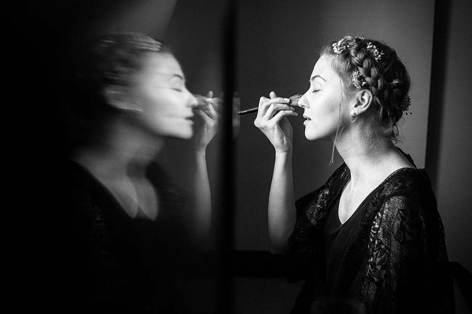Bride applying make-up